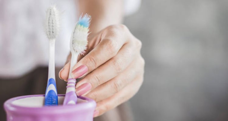 woman hand using old and destroy toothbrush closeup