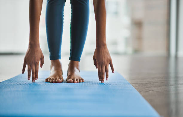 Shot of an unrecognisable woman practicing a yoga routine at home