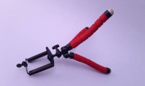 Mini portable tripod for phone photography laying on white background